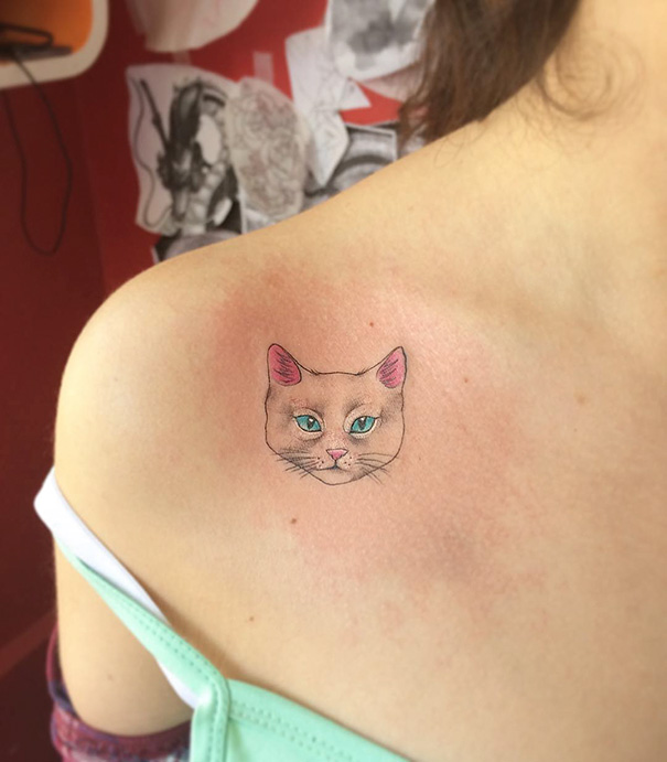 Small cat tattoo on shoulder, featuring a realistic cat face design, perfect for cat person expression.