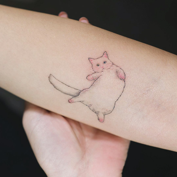 Minimalist cat tattoo on forearm, perfect for cat tattoo ideas enthusiasts.