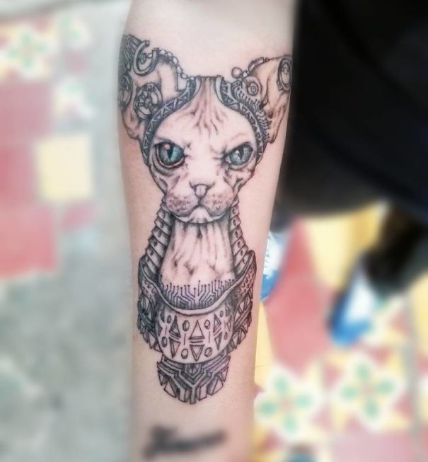 Unique geometric cat tattoo design on forearm, showcasing intricate details for cat tattoo enthusiasts.