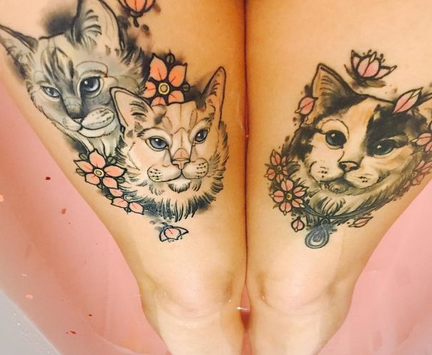 Cat tattoo designs with floral accents on a person's legs.