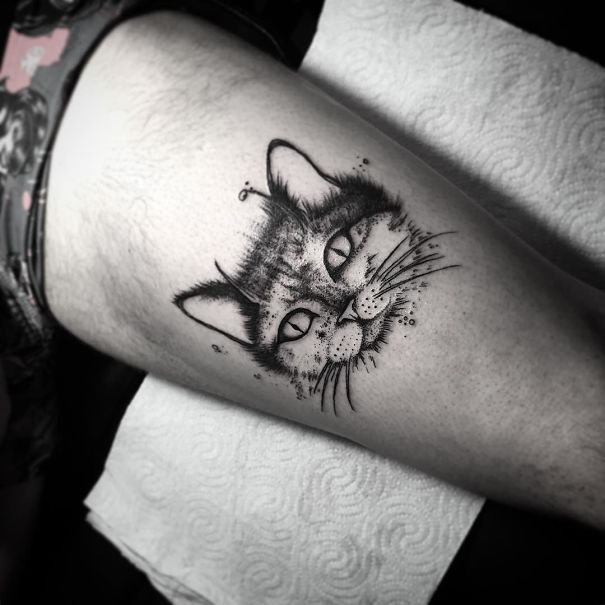 Cat tattoo on thigh showcasing intricate whisker and ear details.