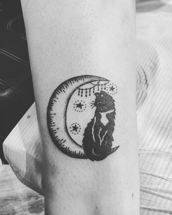 Cat tattoo of a silhouetted feline sitting on a crescent moon with stars, expressing a love for cats.