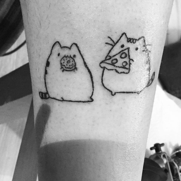 Minimalist cat tattoo with one cat eating a donut and the other a slice of pizza, expressing love for cats.