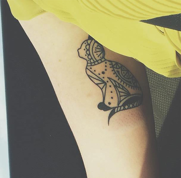 Geometric cat tattoo design on an arm, showcasing intricate patterns, ideal for cat people expressing their passion.