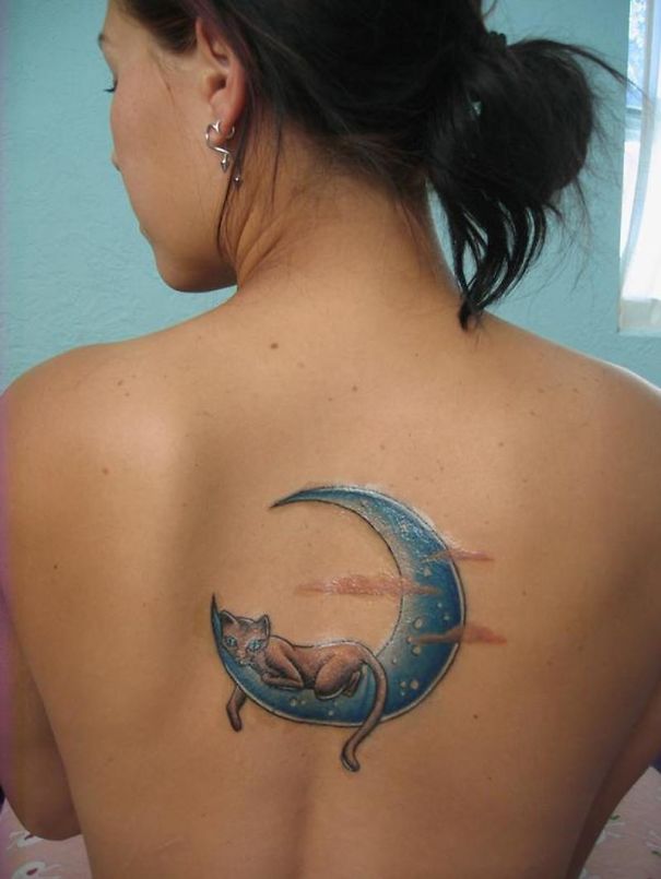 Back tattoo of a cat lounging on a crescent moon, perfect for cat lovers.