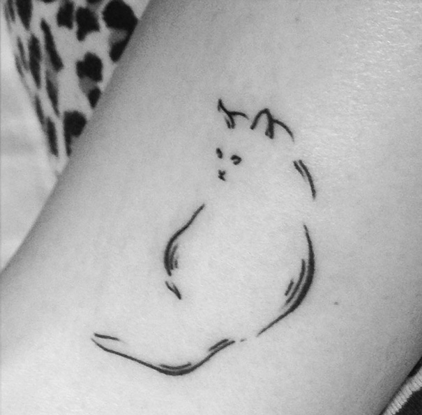 Minimalist cat tattoo design on skin, showcasing a simple outline to express yourself as a cat person.