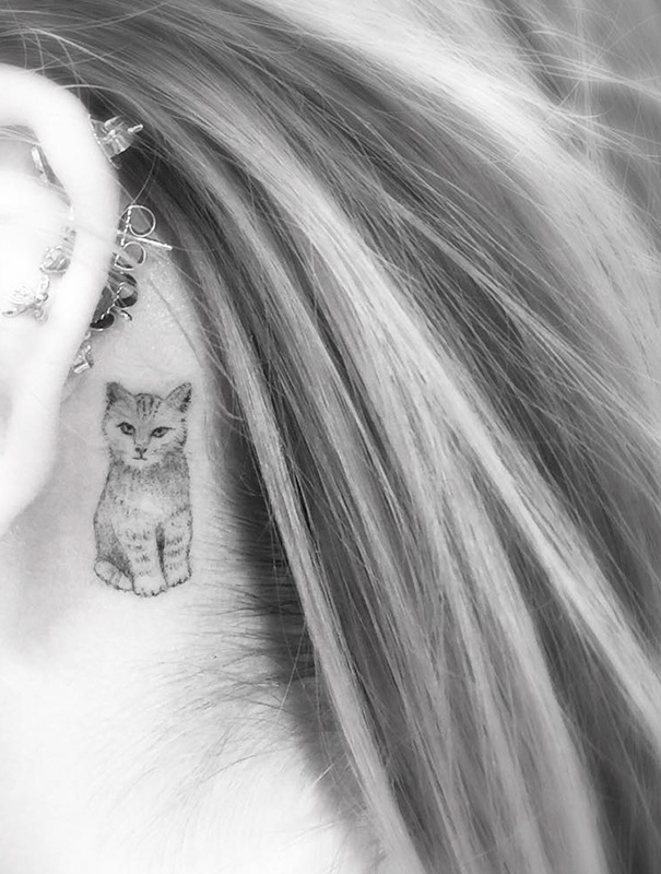Cat tattoo behind ear with delicate details, showcasing a small, artistic feline design for cat lovers.