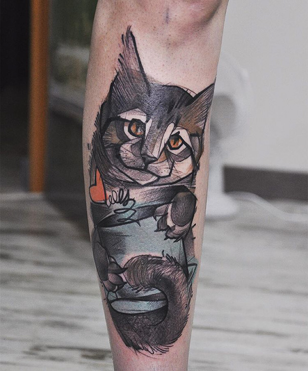 Abstract cat tattoo design on a person's leg, showcasing bold colors and creative style for cat tattoo art enthusiasts.