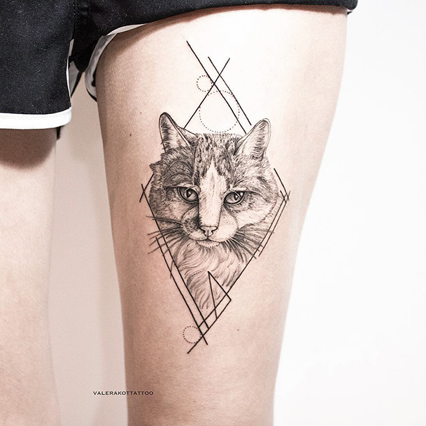 Cat tattoo on thigh featuring geometric elements and realistic cat portrait.