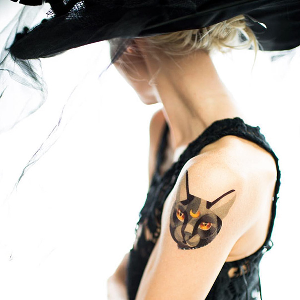 Stylish cat tattoo on woman's shoulder, showcasing a unique design for cat person enthusiasts.