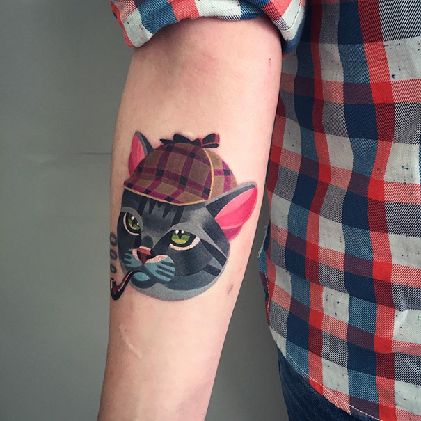 Tattoo of a cat wearing a plaid hat and smoking a pipe, showcasing a unique cat person design.