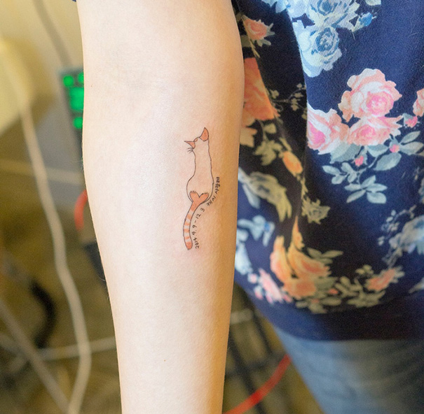 Minimalist cat tattoo on forearm, perfect for expressing your love as a cat person.