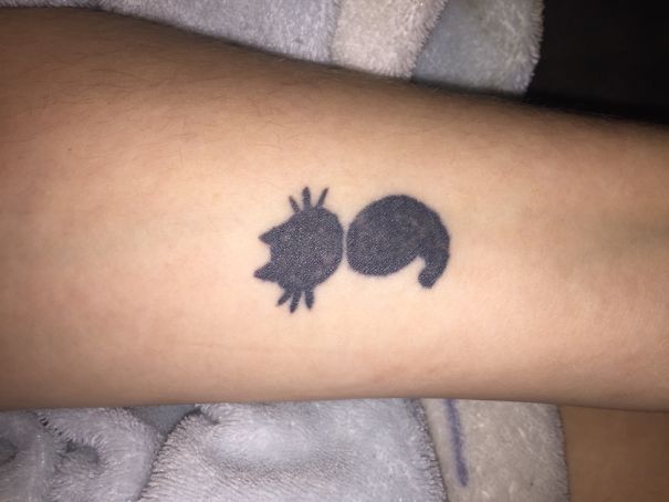 Minimalist cat tattoo on a person's forearm, embodying cat person spirit.