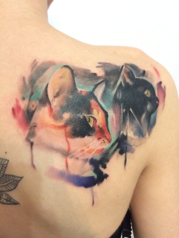 Colorful cat tattoo art on shoulder, showcasing intricate watercolor design for cat person expression.