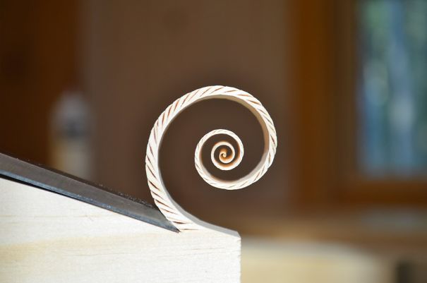 Wood shaving curls in perfect spiral, satisfying perfectionists.