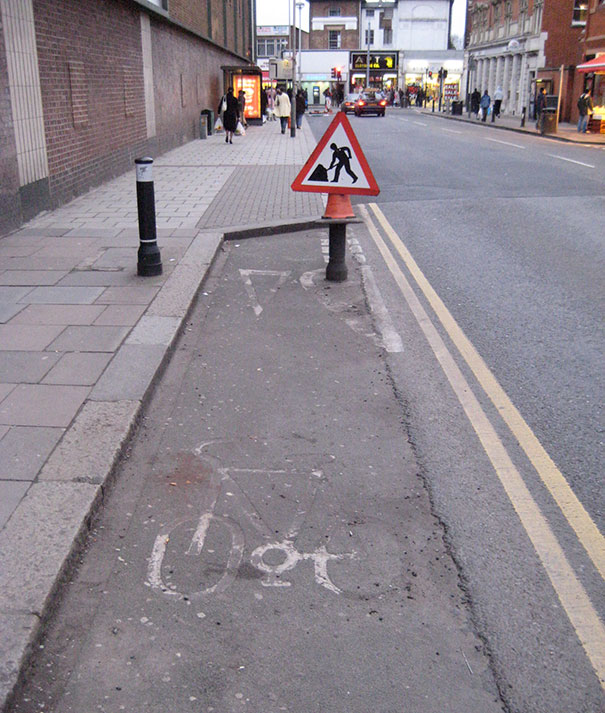 Street and sign with illustration of person digging