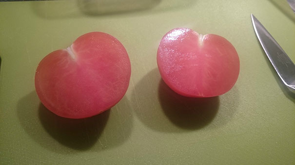 Perfectly sliced tomato on a cutting board, showcasing symmetry that satisfies every perfectionist's eye.