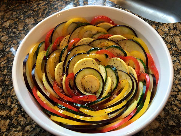Perfectly arranged colorful vegetables in a circular pattern in a white dish, satisfying every perfectionist's soul.