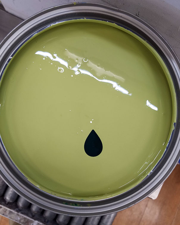 Green paint can with a perfect single drop of darker color in the center, satisfying to perfectionists.