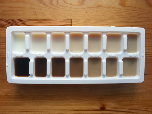 Ice cube tray filled with coffee at varying levels, satisfying perfectionist aesthetics.