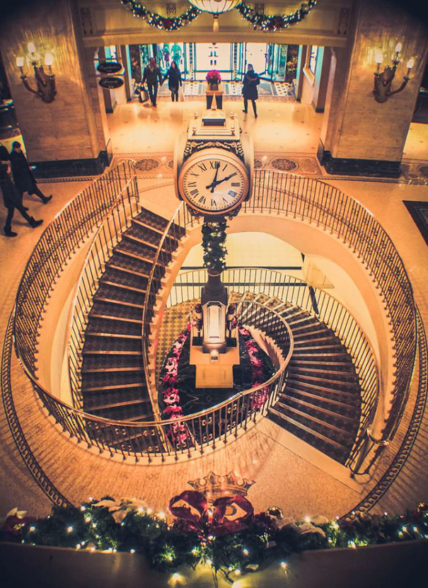 Grand spiral staircase with a central ornate clock, perfect symmetry satisfying for perfectionists.