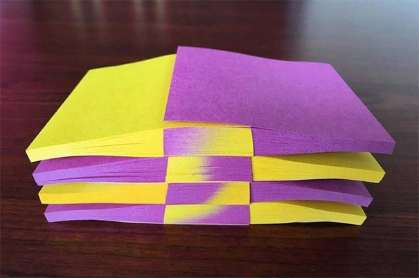 Stack of perfectly aligned purple and yellow sticky notes satisfying perfectionists.