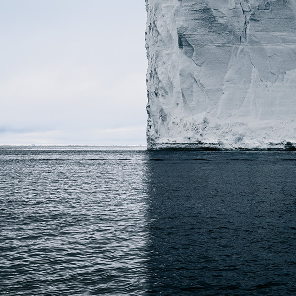 Perfect symmetry of an iceberg's edge against the ocean, satisfying perfectionist's soul.