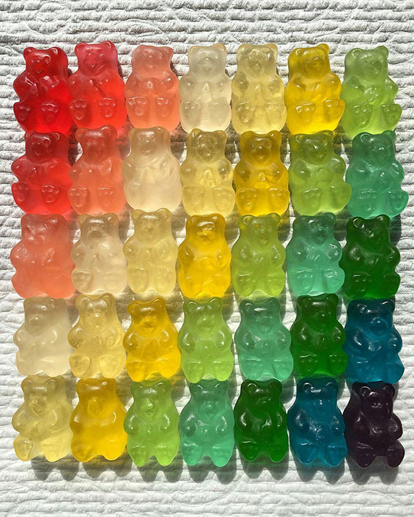 Colorful gummy bears arranged in a perfect grid, showcasing satisfying symmetry and order.
