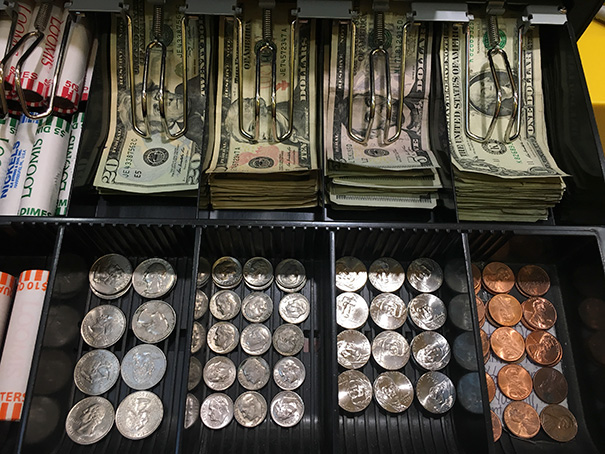 Perfectly organized cash drawer with neatly stacked bills and coins, satisfying every perfectionist's eye.