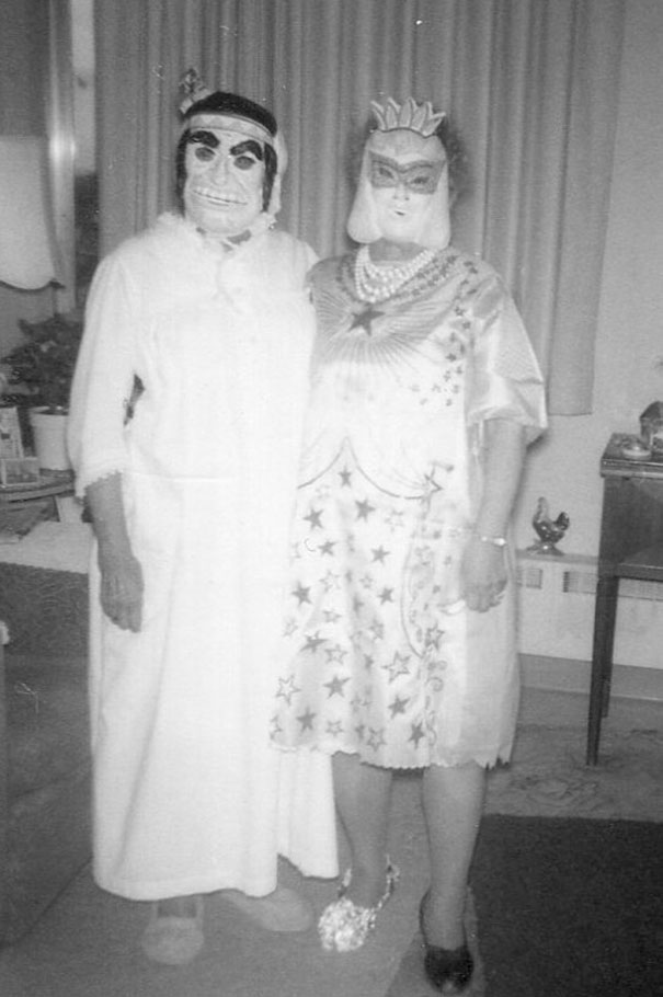 Couple in vintage Halloween costumes wearing masks and star-themed dress, showcasing classic spooky attire from past decades.