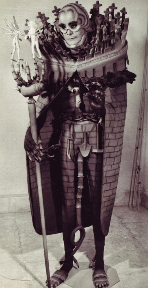 Vintage Halloween costume featuring a detailed surreal design with a large face, crosses, and miniature figures on the shoulders.