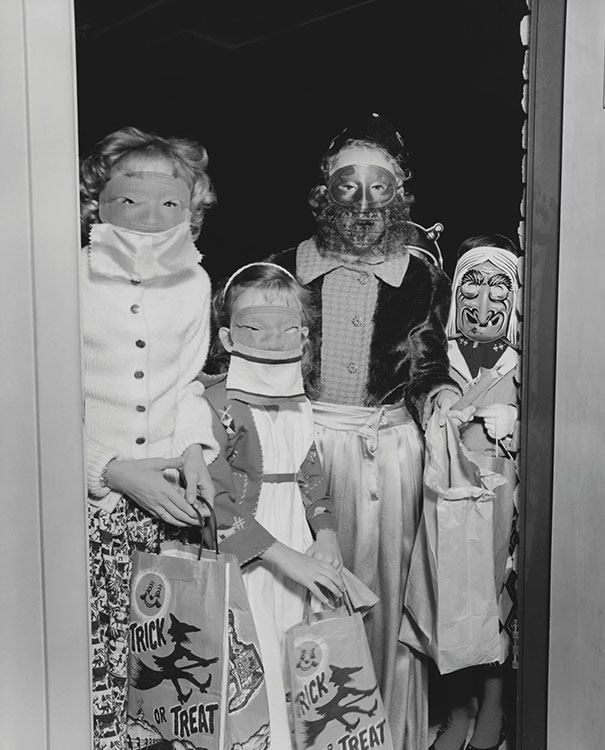Children in vintage Halloween costumes holding trick or treat bags, showcasing classic spooky costume styles from the past.