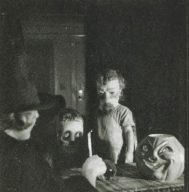 Vintage Halloween costumes featuring eerie puppets and masks in a dark, spooky setting from early 20th century Halloween traditions.