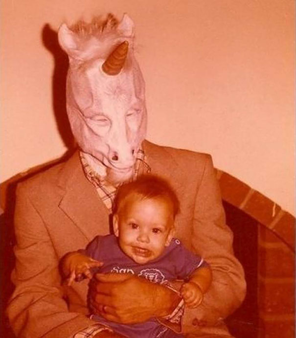 Person wearing vintage unicorn Halloween costume holding a smiling baby, showcasing retro vintage Halloween costumes style.