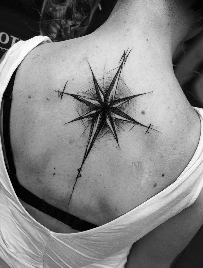 Compass sketch tattoo on a person's back, showcasing the beauty of imperfection by a Polish tattoo artist.