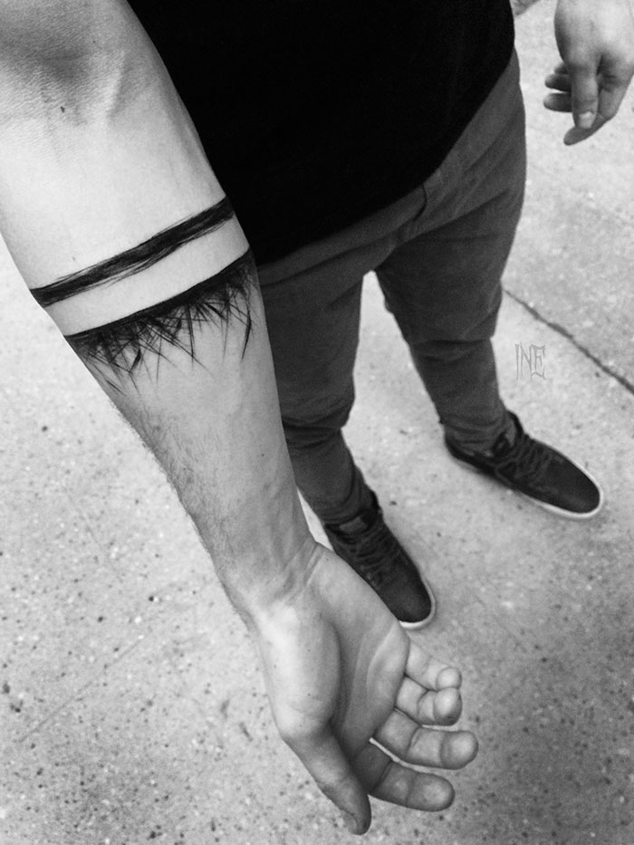 Sketch tattoo of geometric lines on a person's forearm, showcasing the beauty of imperfection by a Polish tattoo artist.