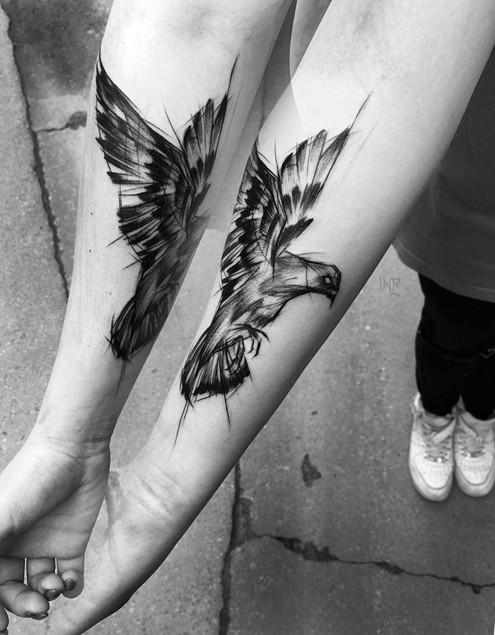 Forearm with sketch tattoos of two birds in flight by Polish tattoo artist, showing beauty of imperfection.