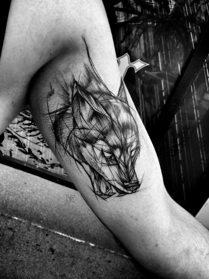 Sketch tattoo of a wolf on an arm by Polish tattoo artist, showcasing beauty in imperfection.