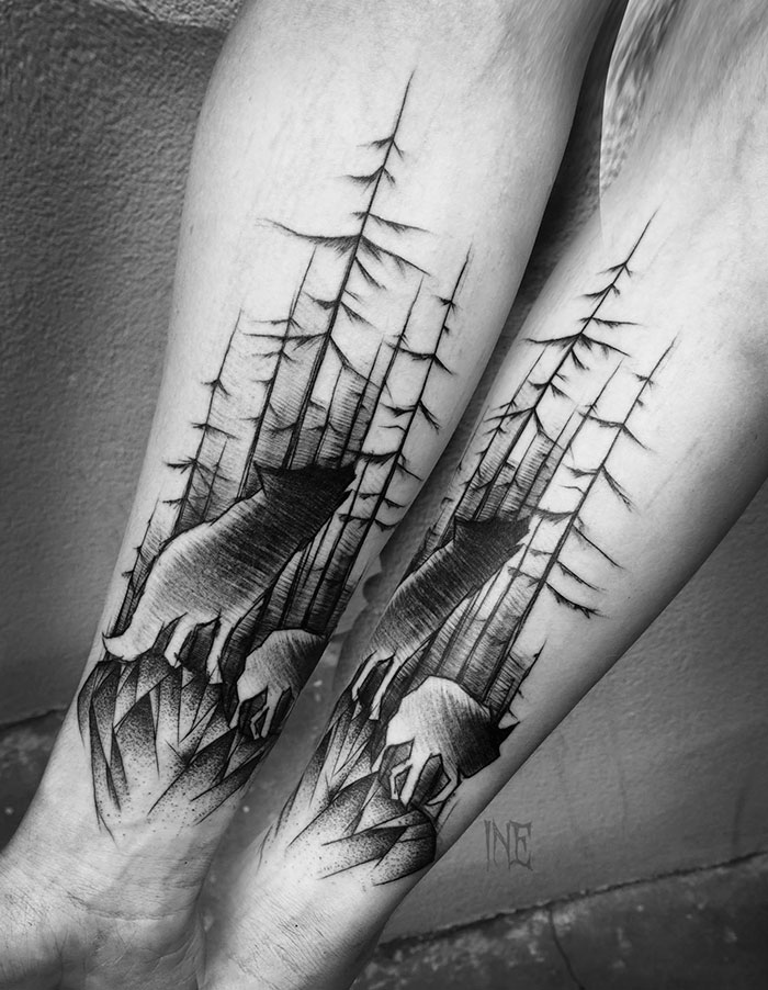 Sketch tattoo of a wolf and trees on a person's forearm, showcasing beauty and imperfection by Polish tattoo artist.
