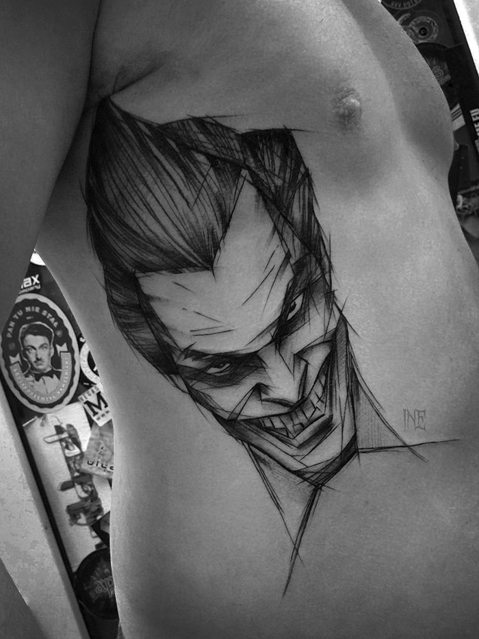 Sketch tattoo of a stylized face on a person's side, showcasing the beauty of imperfection by a Polish tattoo artist.