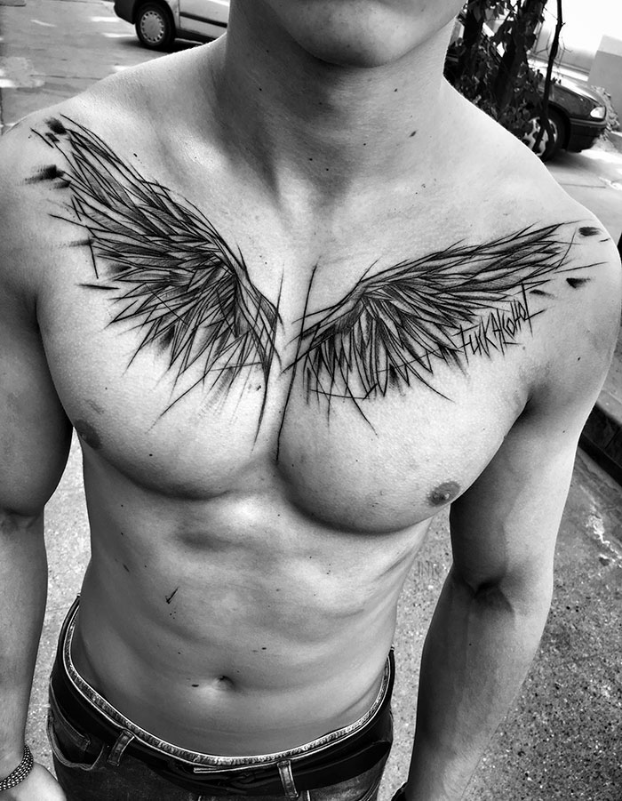 Chest with sketch tattoo of wings by Polish tattoo artist, showcasing the beauty of imperfection.