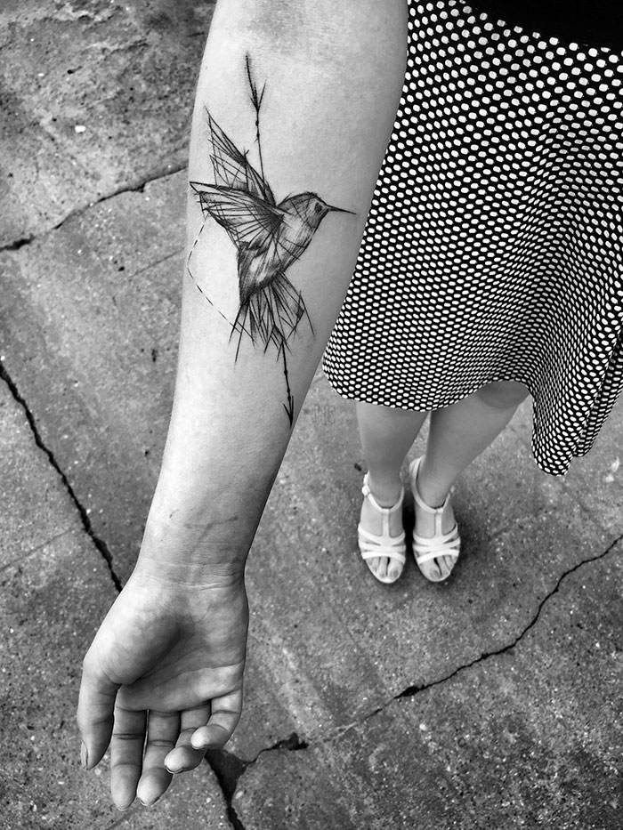 Sketch tattoo of a hummingbird on a woman's forearm, showcasing the beauty of imperfection in Polish tattoo art.