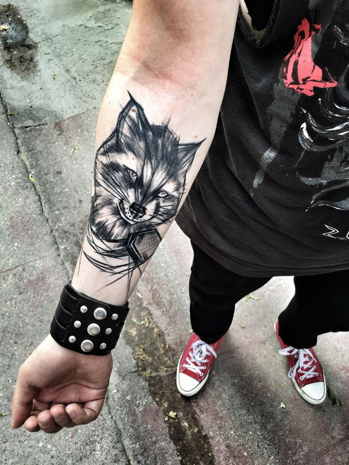 Sketch tattoo of a wolf design on a forearm by Polish tattoo artist, showcasing the beauty of imperfection.