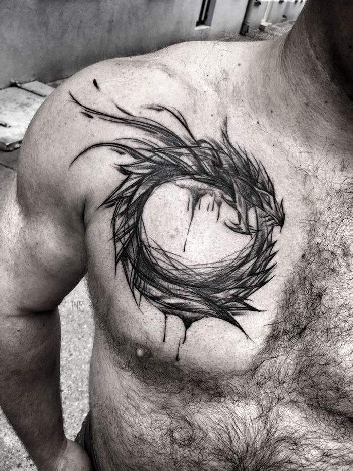 Sketch tattoo on a person's chest depicting a circular, abstract design highlighting artistic imperfections.