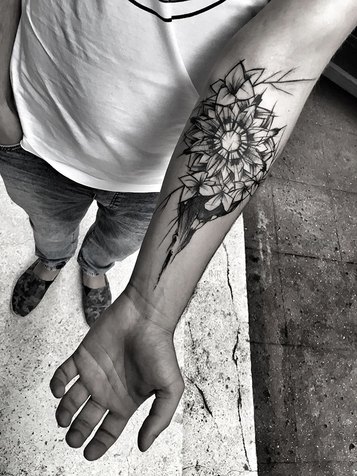 Person displaying a detailed flower sketch tattoo on their forearm, showcasing the beauty of imperfection.