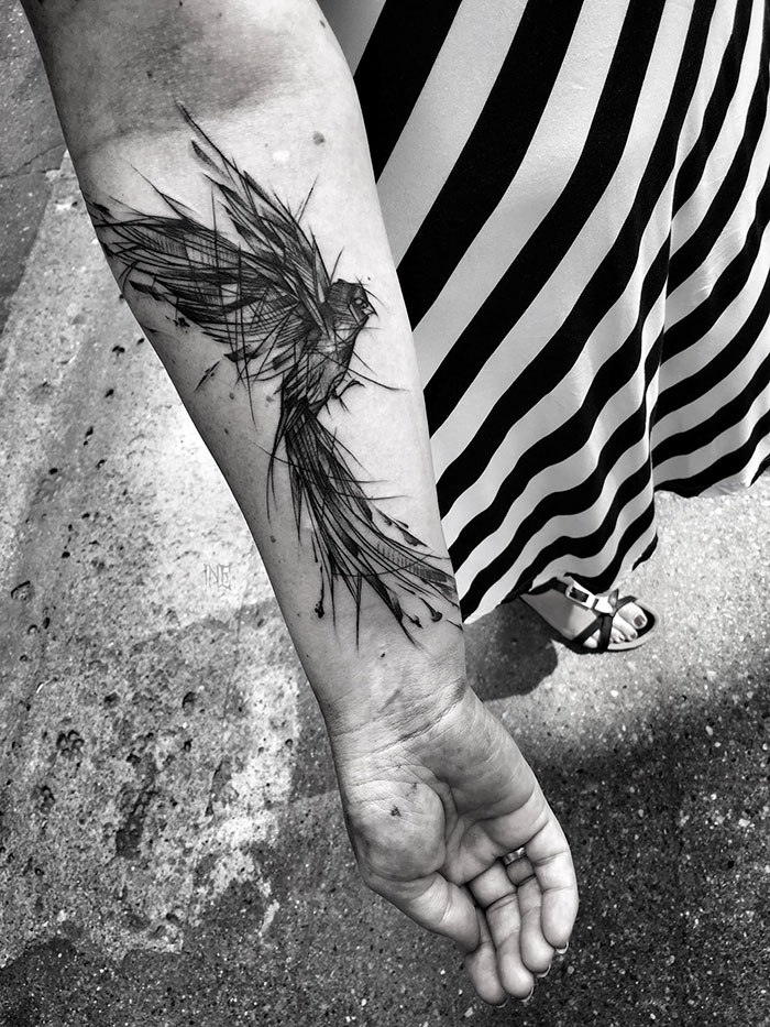 Sketch tattoo of a bird on a person’s forearm, showcasing the beauty of imperfection by a Polish tattoo artist.