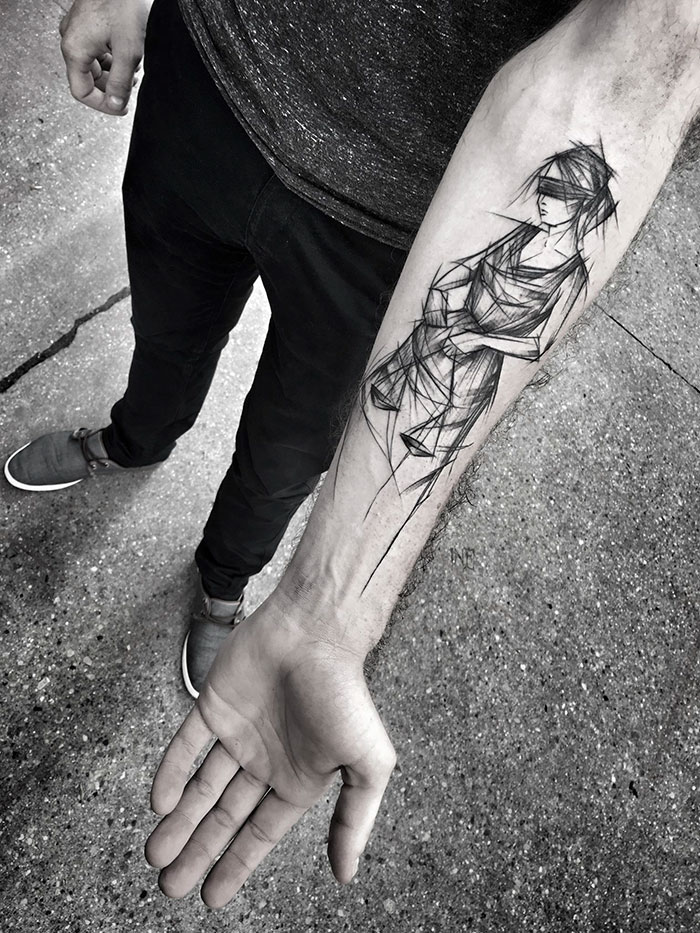 Sketch tattoo by Polish artist on a person's forearm, showcasing a stylized figure with an artistic imperfection.