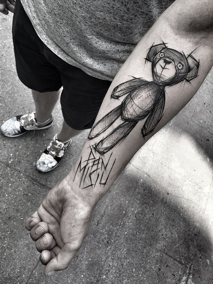 Sketch tattoo of a bear on a person's arm, showcasing the beauty of imperfection by a Polish tattoo artist.