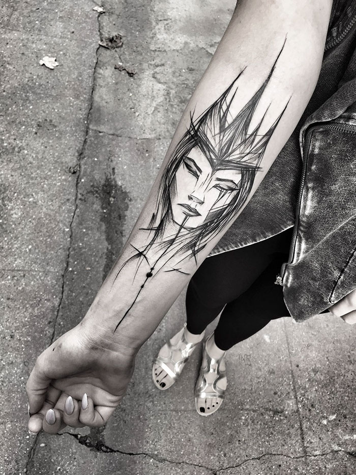 Sketch tattoo on forearm by Polish artist, showcasing beauty of imperfection with abstract face design.