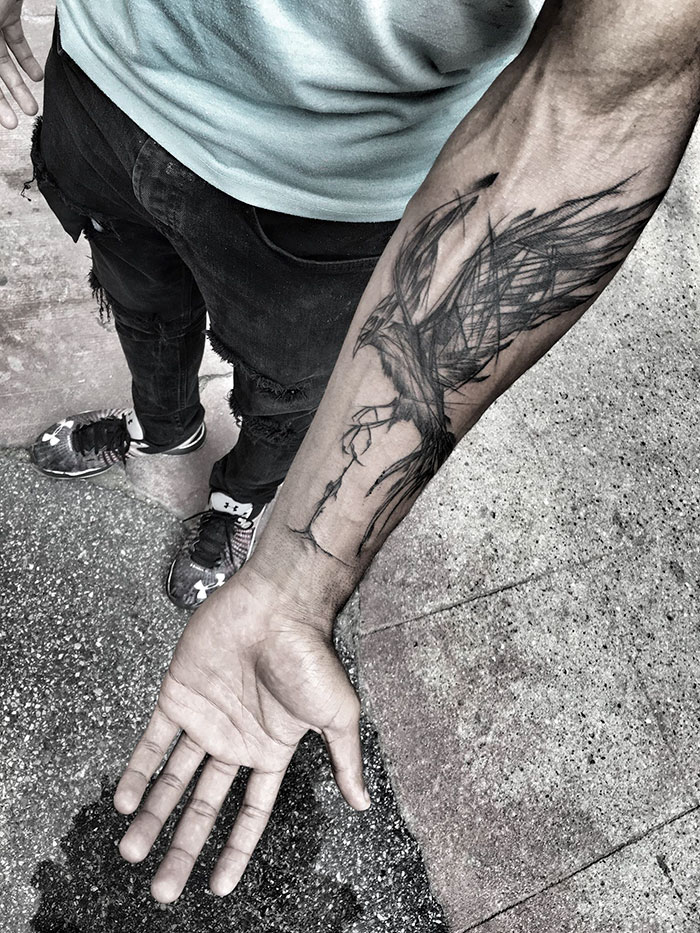Arm featuring a sketch tattoo of a bird, showcasing the beauty of imperfection by a Polish tattoo artist.